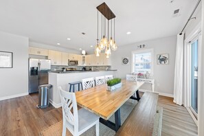 A modern kitchen with a central island, stainless steel appliances, and pendant lighting.