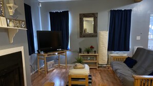 A living room with a television, sofa, and a bench. - A cozy little place with 2 bedrooms all to yourself (Hartford)