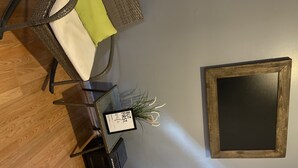 A dining area with wicker chairs, a table, and a framed picture on the wall. - A cozy little place with 2 bedrooms all to yourself (Hartford)