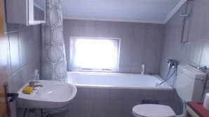 Ein Badezimmer mit Badewanne, Toilette und Waschbecken.