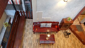A spacious room with a wooden bench, a small table, and a fan. - 14 Plus 1 Hotel (Bangkok)