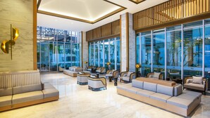 A spacious lobby with modern furniture, large windows, and a polished marble floor. - Swiss-Belhotel Solo (Surakarta)