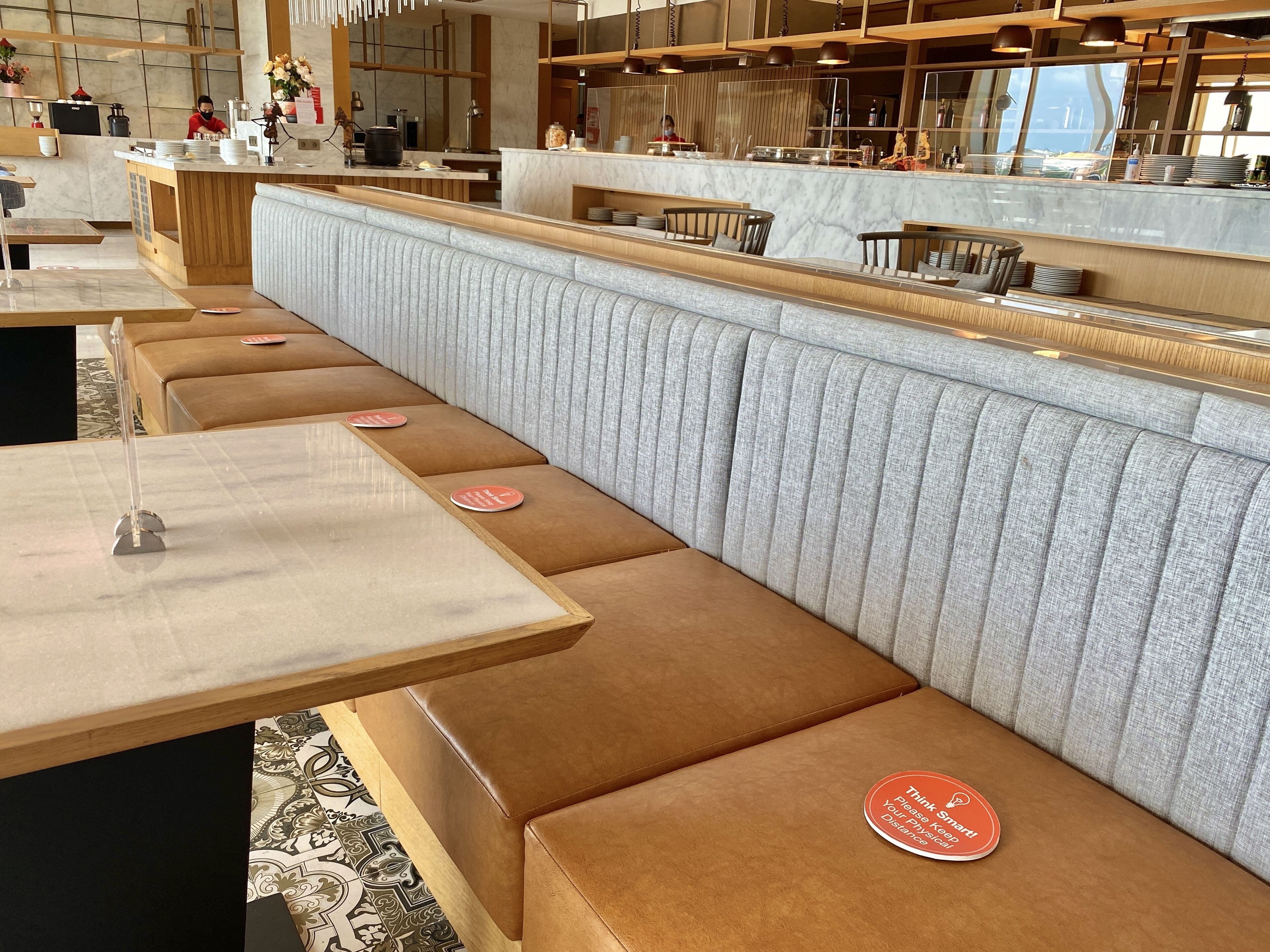 Un restaurante moderno con una barra alargada, asientos acolchados y una distribución limpia y ordenada.