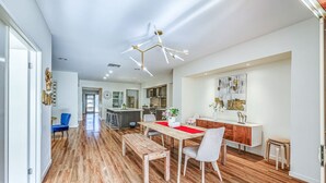 Una cocina moderna con una isla central, piso de madera y una lámpara de techo contemporánea.