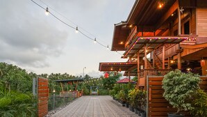 A wooden building with a covered porch and potted plants. - Villa Robert (Manado)