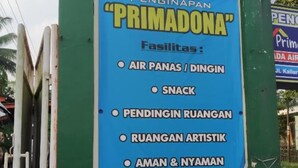 Un panneau publicitaire annonçait un établissement ouvert 24 heures sur 24, nommé « PRIMADONA », et proposant divers services, notamment des distributeurs automatiques de nourriture, des collations, des espaces de repos, des activités artistiques et une salle réservée aux hommes et aux femmes.