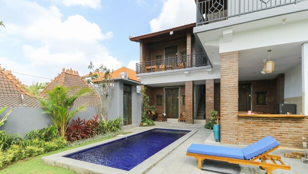 A modern house with a swimming pool, a lounge chair, and a balcony. - The Tristan Bali (Canggu)