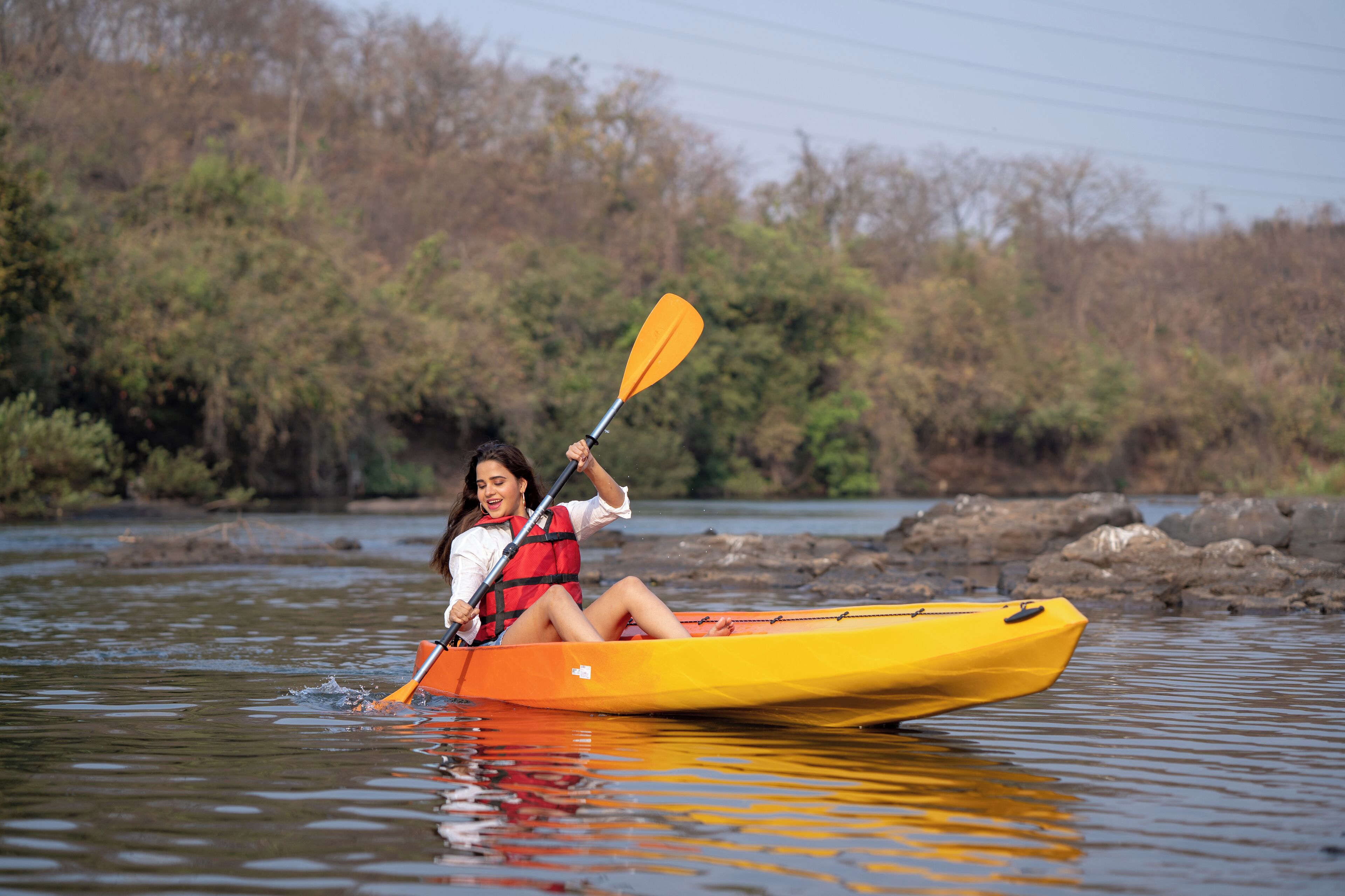 Una persona en un kayak amarillo en un río.