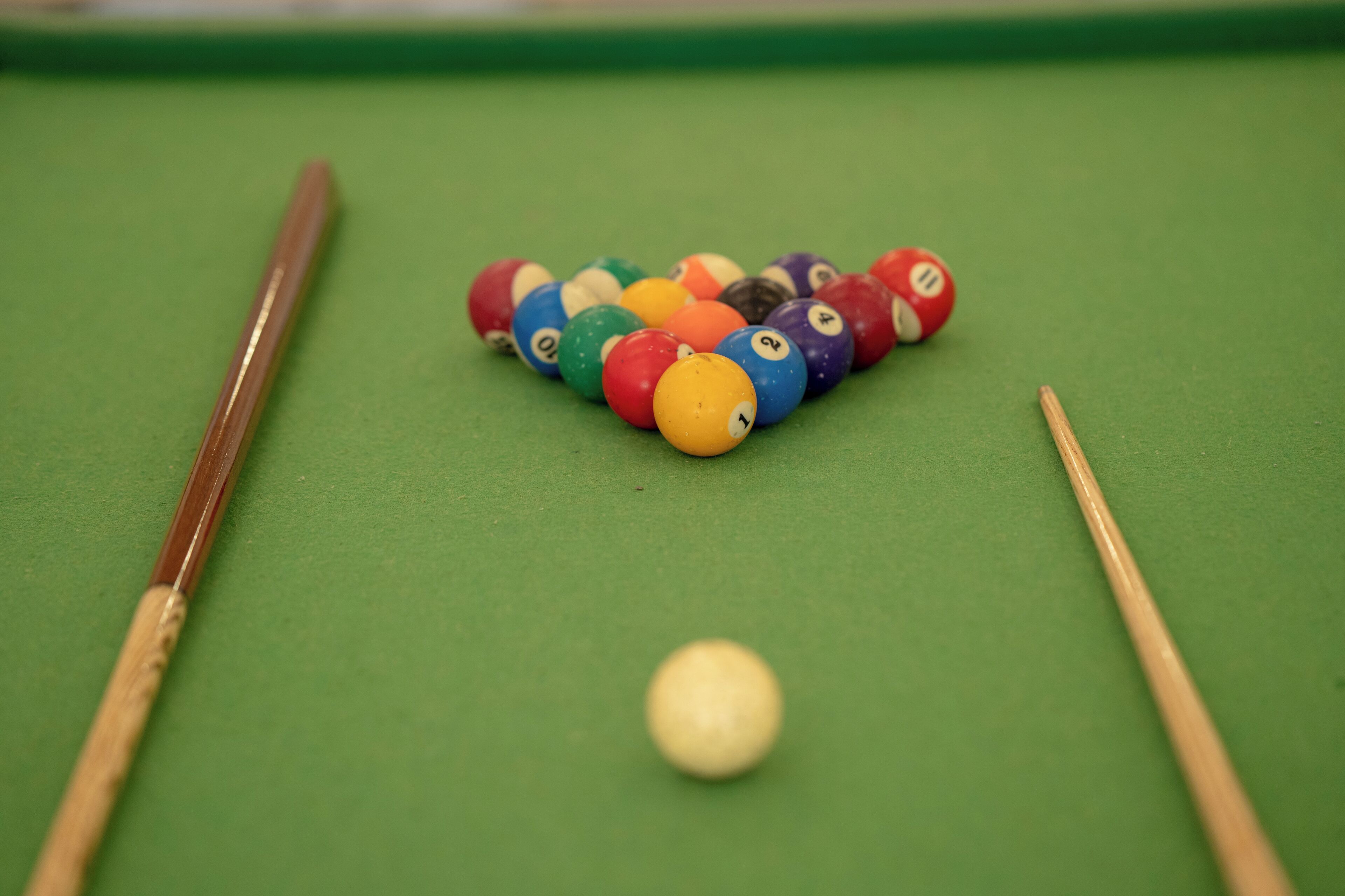 A pool table with colorful balls and a cue stick.