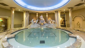 A grand indoor pool with a central fountain, surrounded by classical columns and marble flooring. - At RLiS House Tsutenkaku (Osaka)