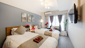 A hotel room with two beds, a flat-screen TV mounted on the wall, and a window with curtains. - At RLiS House Tsutenkaku (Osaka)