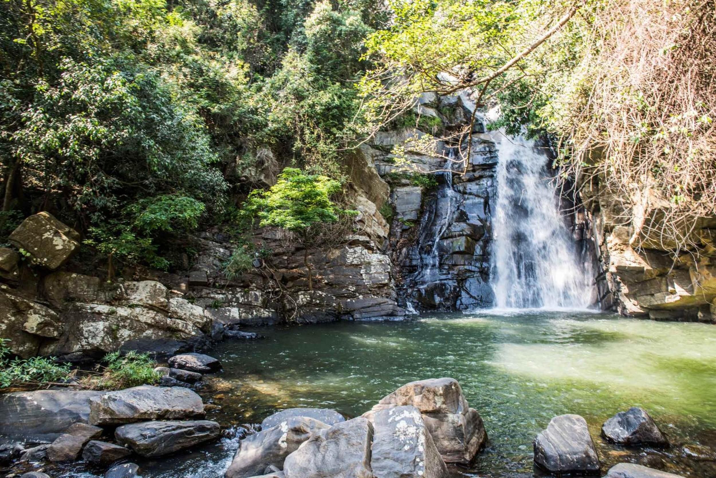 Une cascade naturelle, entourée de rochers et de verdure.