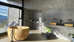 Een moderne badkamer met een groot houten wastafelblad, een douche en een wastafelmeubel met twee wasbakken.
