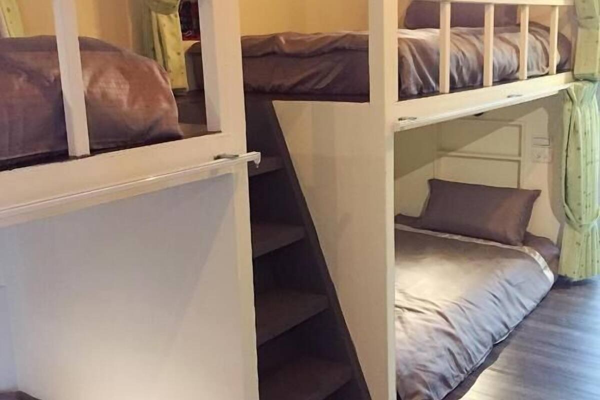 A bunk bed room with a staircase leading to the upper bunk.