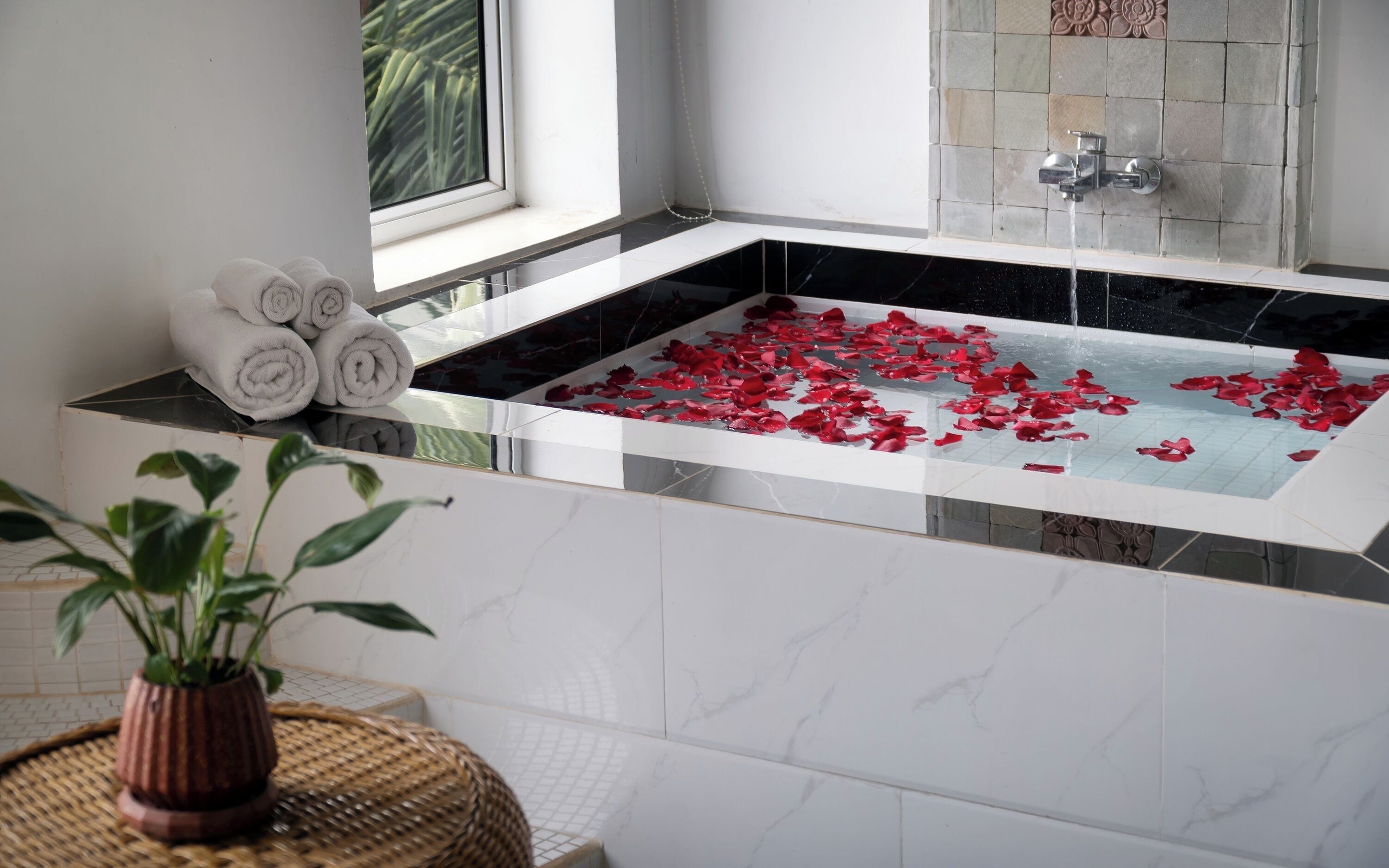 Un baño moderno con una bañera grande, una ventana y una zona de ducha.