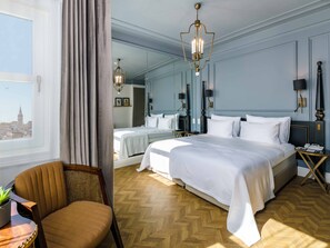 A hotel room with a large bed, two bedside tables, a chair, and a view of a cityscape through a window. - The Soul Istanbul Hotel (Istanbul)