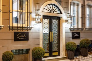 Fachada de un edificio con una puerta negra, dos plantas en macetas y un letrero que dice "The Soul Istanbul".