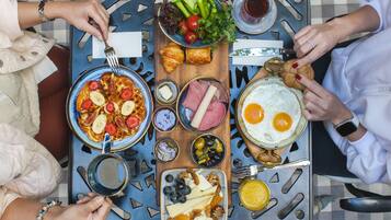 A breakfast buffet with various food items and drinks.