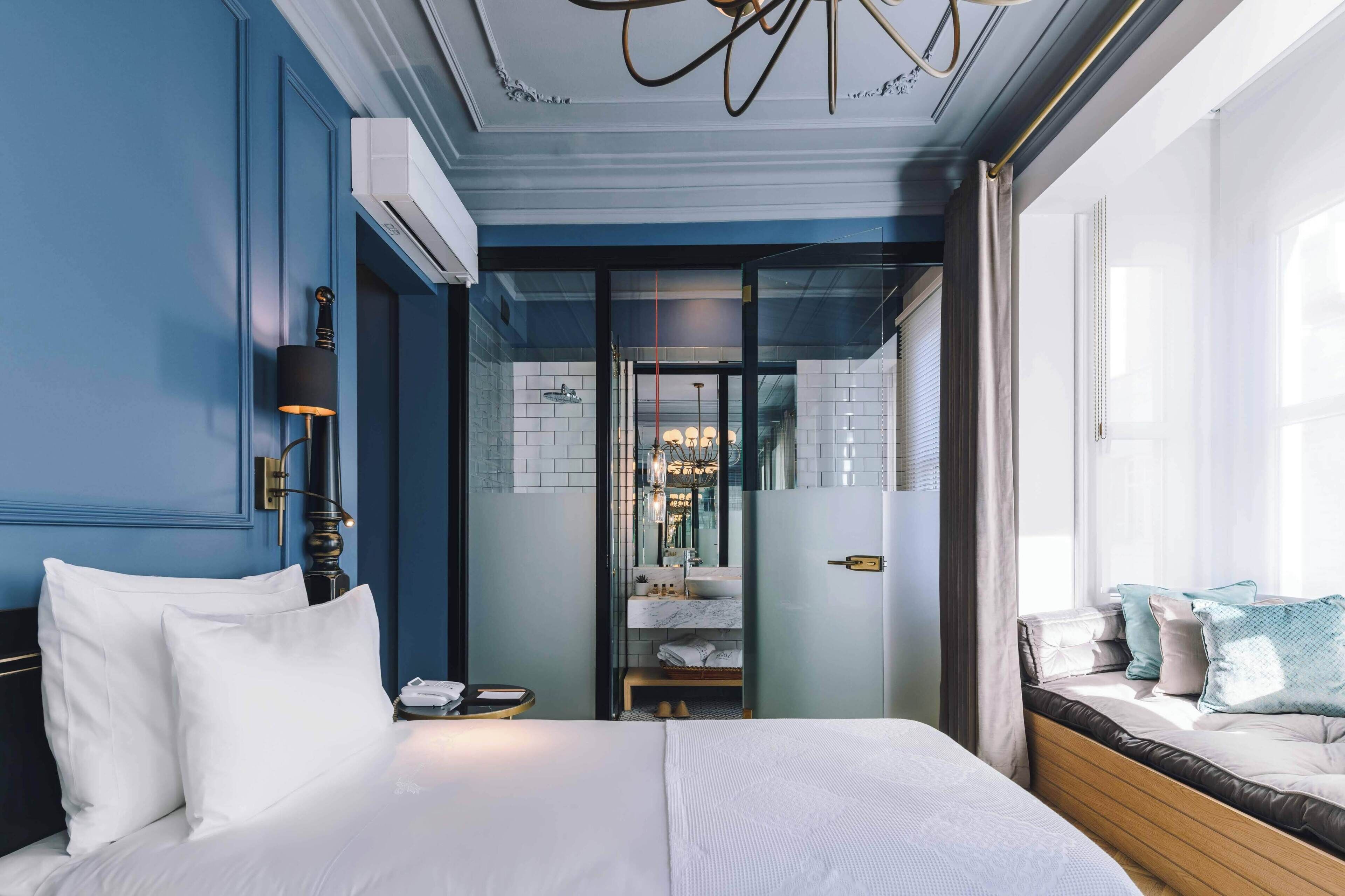 A hotel room with a bed, bedside table, and a view of the bathroom.