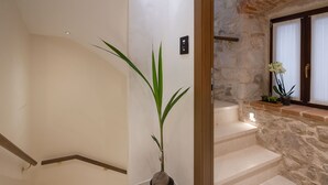 A staircase with a stone wall and a potted plant. - Luxury Rooms MA de Dominis - Adults Only (Split)