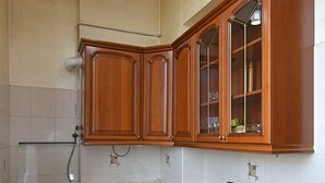 A kitchen with wooden cabinets, a stainless steel stove, and a sink. - Luxury apartment in Yerevan (Arabkir)