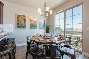 Enjoy a formal dining experience with a round table set for four, complete with napkins, cutlery, and wine glasses.