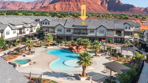 A residential area with multiple houses, a swimming pool, and a mountain in the background.