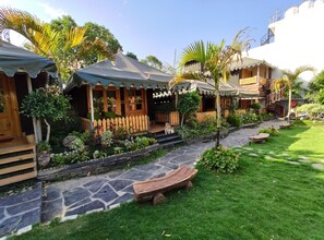 Une maison traditionnelle en bois, avec un chemin de pierre menant à une terrasse en bois.
