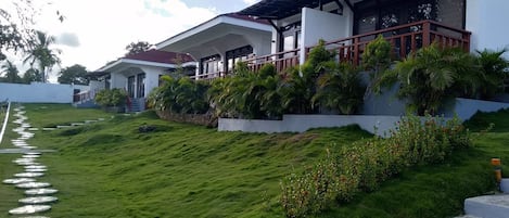 A modern house with a covered porch and a stone pathway leading to the entrance.