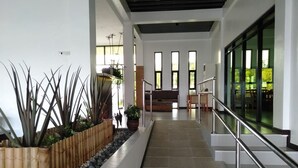 Un interior moderno con una escalera, una zona de estar y vistas al exterior.