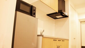 A kitchen with a built-in microwave, a stainless steel range hood, and wooden cabinets. - Mango Resort Okinawa Naha (Naha)