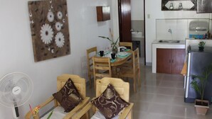 Un espacio habitable compacto con comedor, cocina y ventilador.