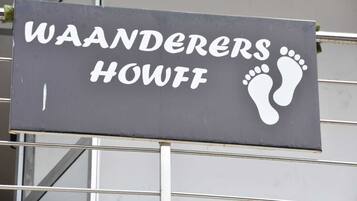 A sign with the text "WAANDERERS HOWFF" and footprints.