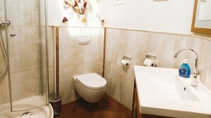 A bathroom with a shower, toilet, and sink.