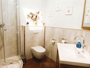 A bathroom with a shower, toilet, and sink.