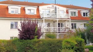 A two-story building with a balcony and a sign that reads 'STRANDKINE'.