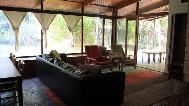 A cozy living room with a sofa, chairs, and a dining table. - Large family home Stellenbosch cbd (Stellenbosch Central)