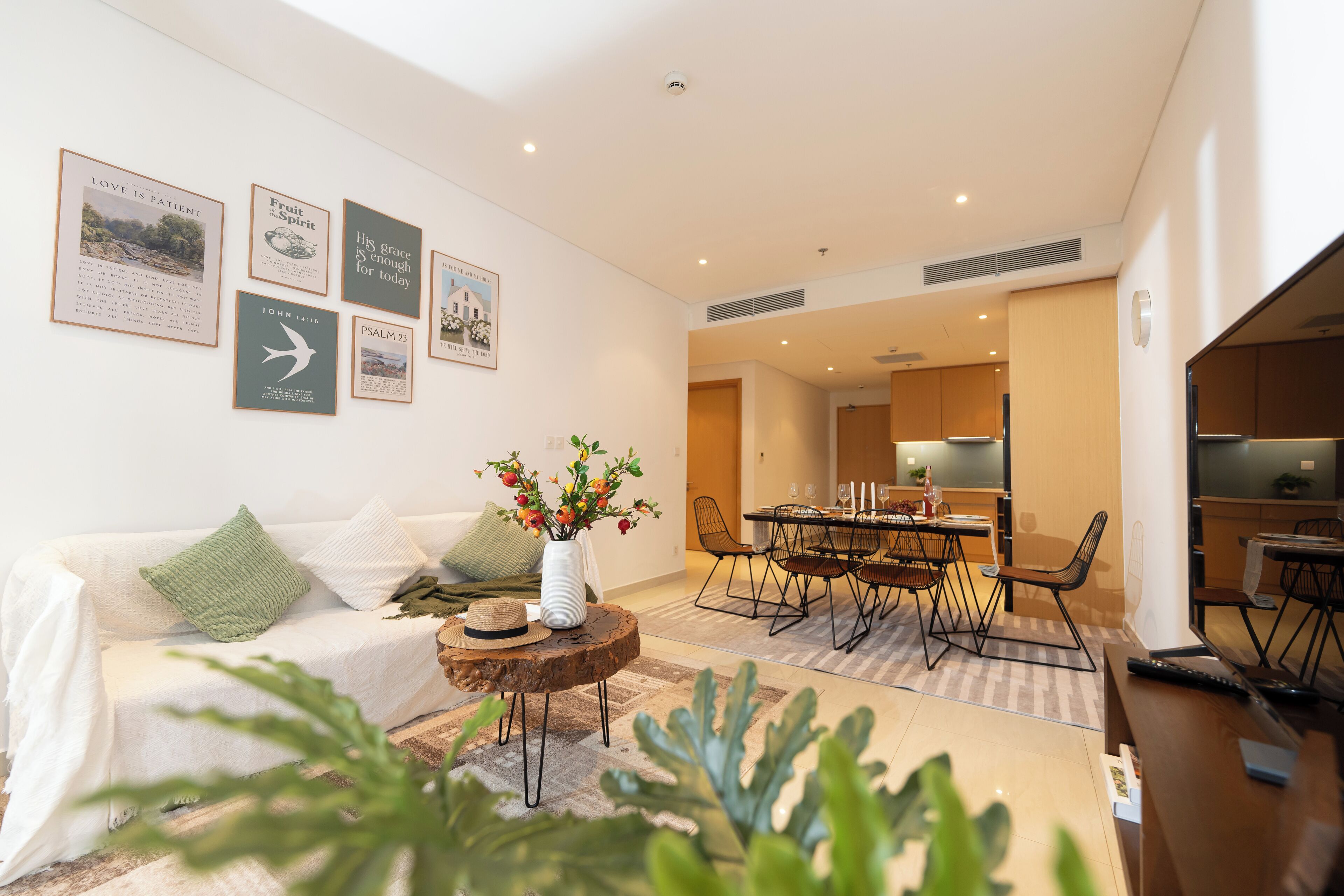 A modern living room with a sofa, coffee table, and a dining area with chairs and a table.