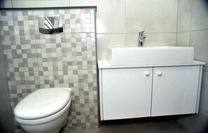 A bathroom with a toilet, a sink, and a cabinet. - Amazing one Bedroom Apartment in Amman,elwebdah 6 (Amman)