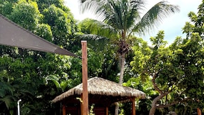 A clear swimming pool with lounge chairs and a thatched-roof structure. - Domaine Saint-François (Saint-François)
