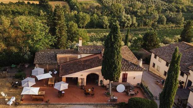 Una villa con patio, mobiliario exterior y vistas a viñedos.