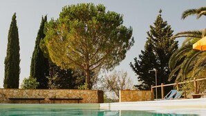 Una piscina con paredes de piedra y valla de madera.