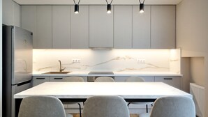 Una cocina moderna con encimera de mármol, alacenas integradas y una isla central con asientos.