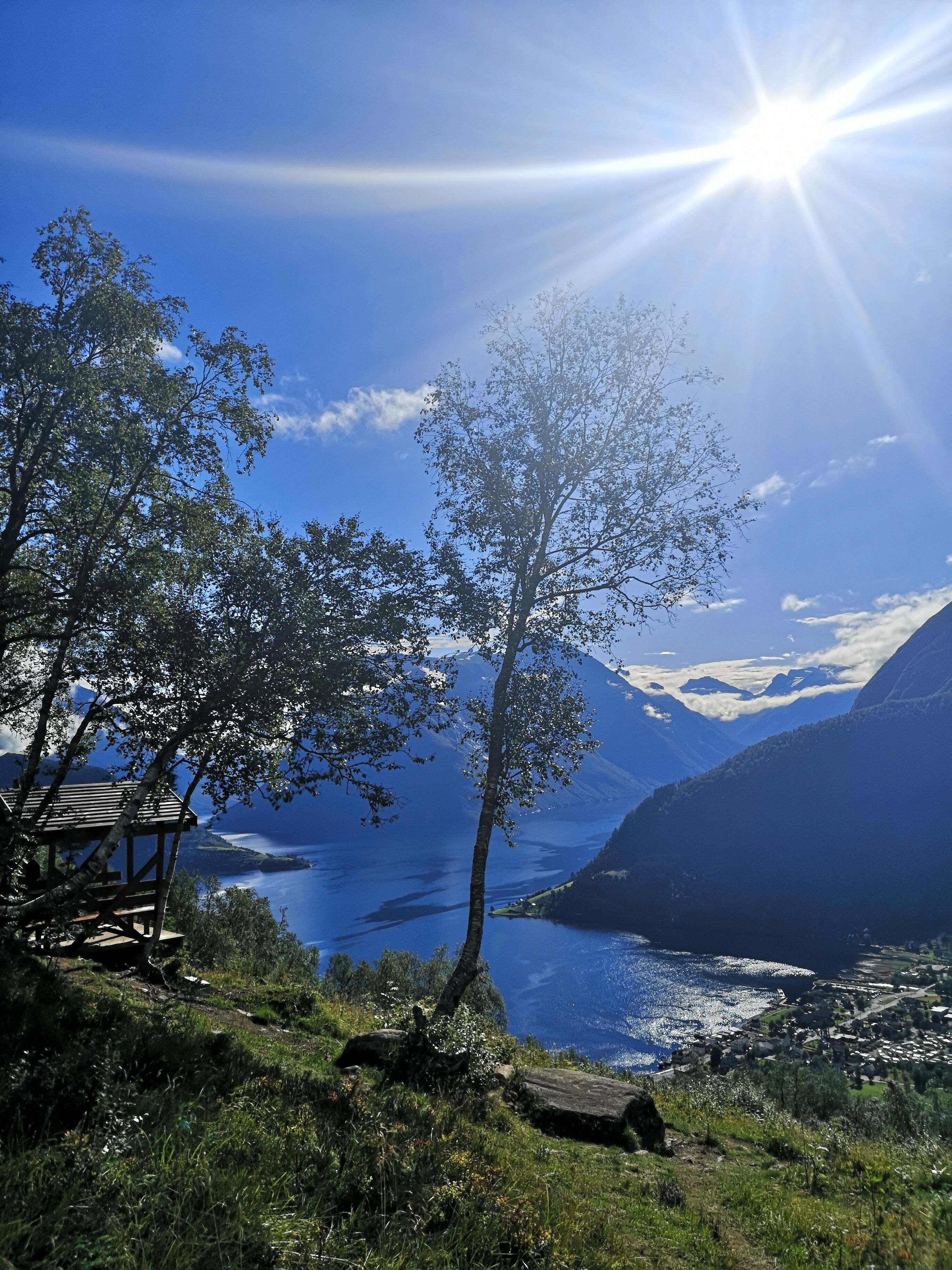 A wooden observation deck overlooking a lake with mountains in the background.