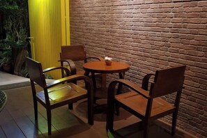Un muro de ladrillo con una mesa redonda y cuatro sillas.