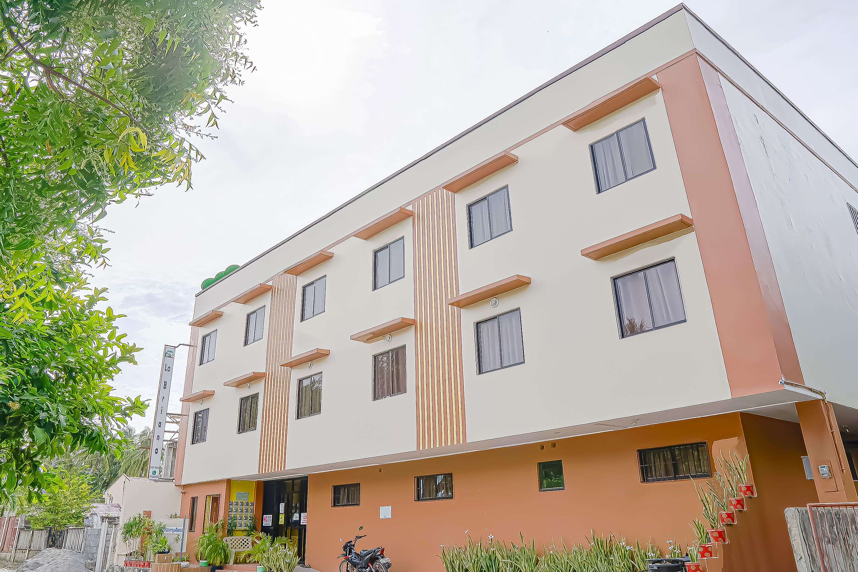 A multi-story building with a flat facade, multiple windows, and a central entrance.