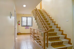 A staircase with wooden steps and metal railings, leading to an upper floor. - OYO 592 La Briana Guest House (Santa Fe)