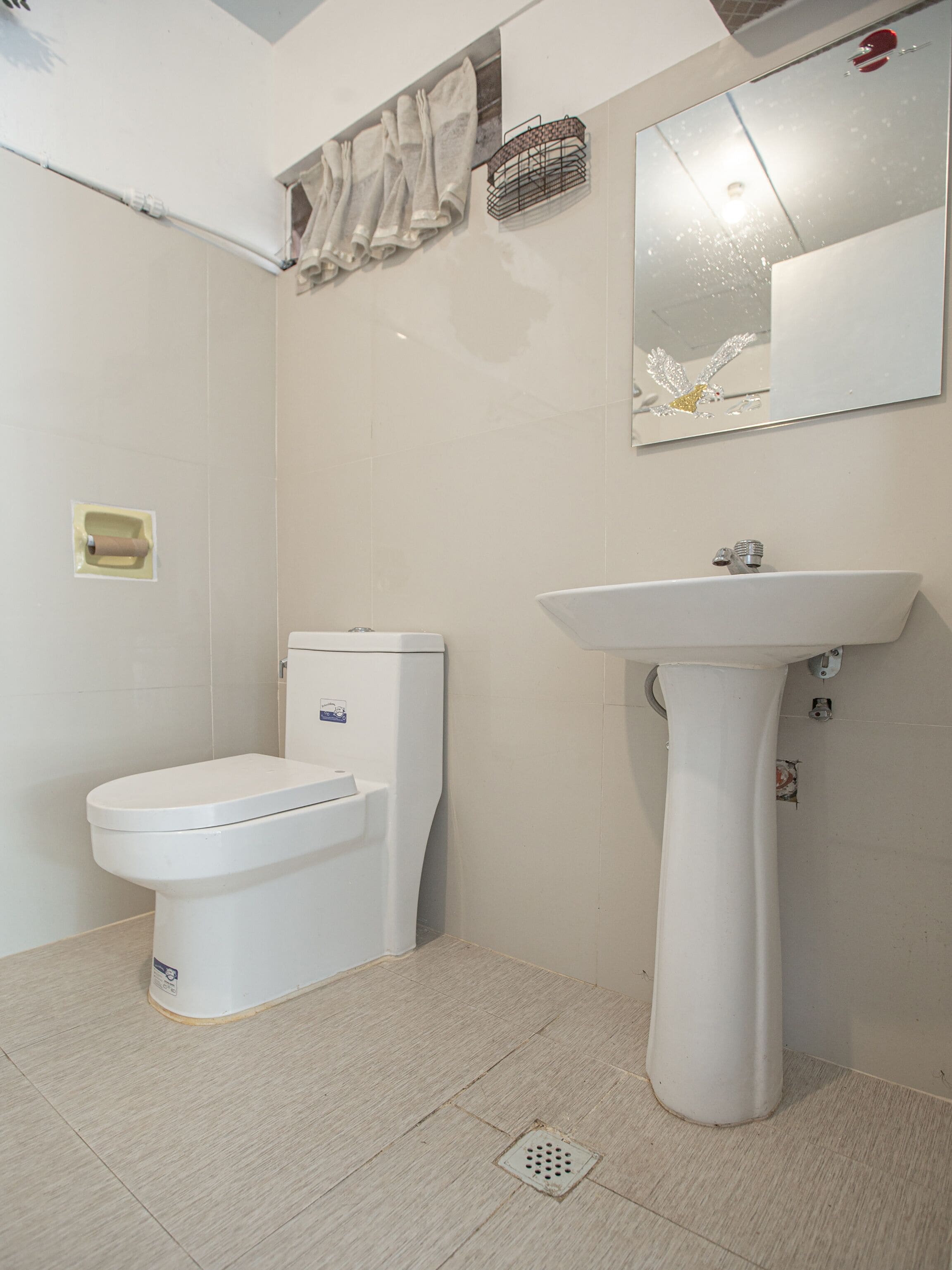 Une salle de bain avec des toilettes, un lavabo et un miroir.