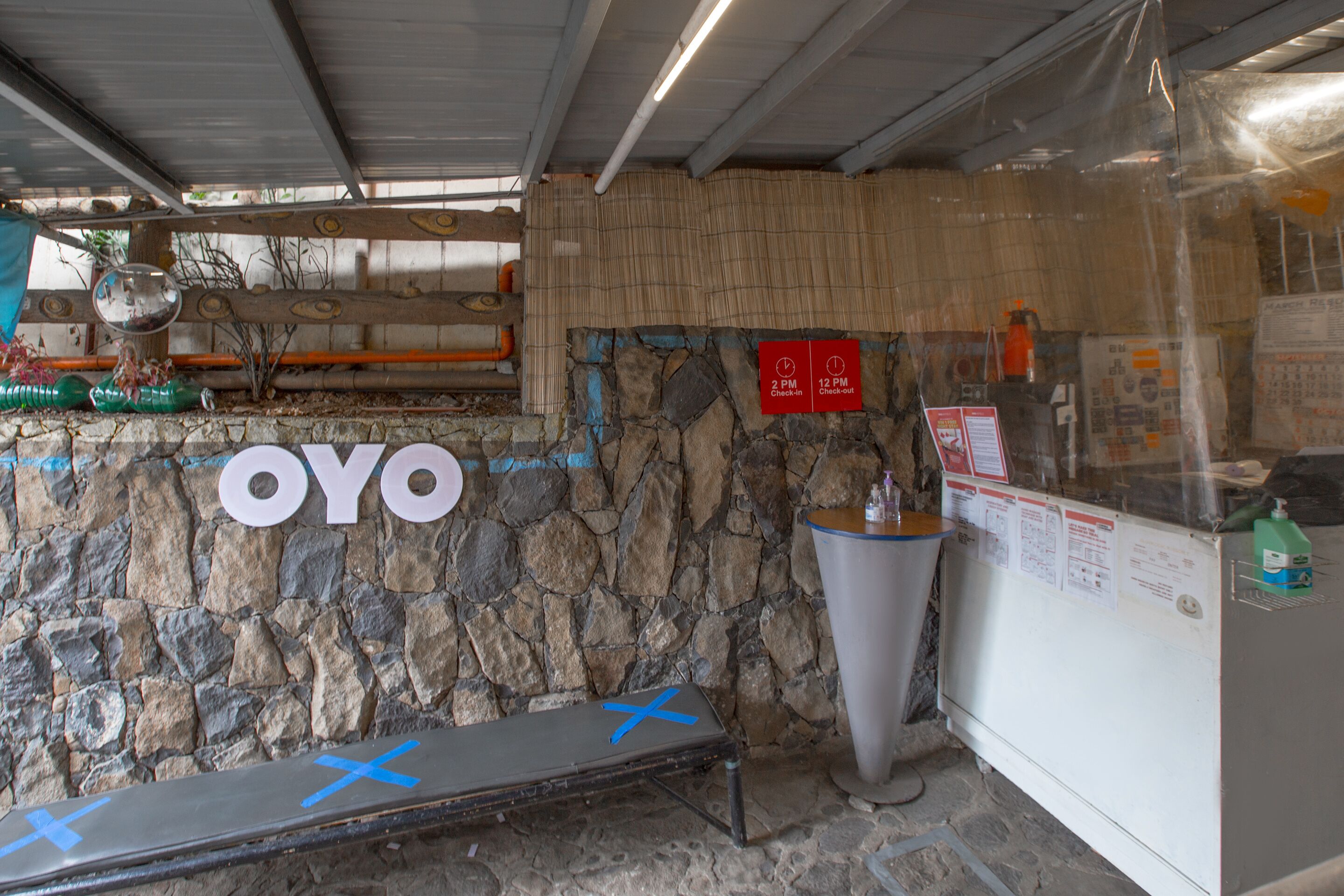 A stone wall with the name "OYO" and a bench with blue X marks.