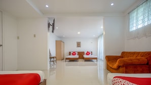 A hotel room with two beds, a sofa, a wooden cabinet, and a framed picture on the wall. - OYO 588 Sunrock Resort (Antipolo)